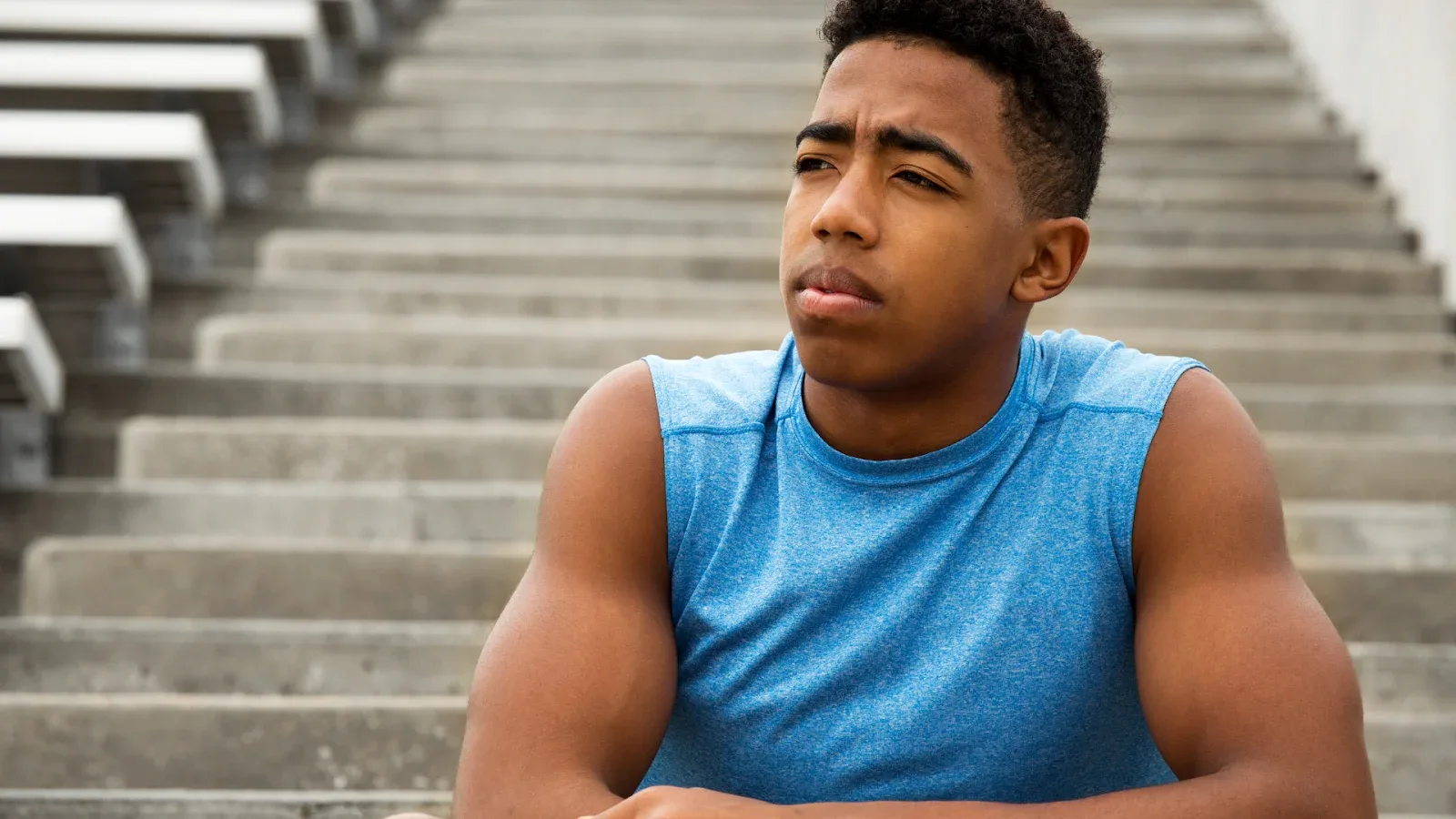 athlete sitting on stairs and looking into the distance